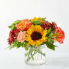 Mixed bouquet with a sunflower, roses, and chrysanthemums in a glass vase