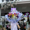 Bouquet of pink tulips and mixed flowers topped with a purple plush cat