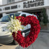 Heart-shaped red rose arrangement with white lilies on a stand