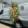 Tall floral standing spray with red, white, and green blooms