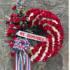 Large red and white rose wreath with a "WE REMEMBER" ribbon