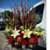 Tall red and white floral arrangement in a white vase