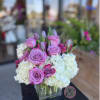 Pink roses and white hydrangeas arranged in a clear square vase