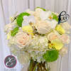 White and pale peach bouquet with green mums in a glass vase