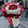 Bouquet of red roses with white baby's breath in pink wrapping