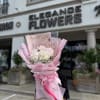 Pink-wrapped bouquet of white and pale pink flowers