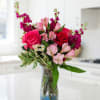 Pink and red flower bouquet in a clear glass vase