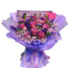 Pink roses with purple filler flowers wrapped in lavender paper