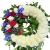 Heart-shaped floral wreath with white chrysanthemums, red and white roses, and blue flowers