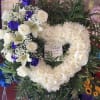 Heart-shaped floral wreath with white roses, lilies, and purple roses