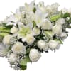 White lilies and roses arranged in a bouquet with baby's breath