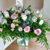 Pink and white rose arrangement in a white vase
