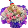 Pink roses arranged with a teddy bear in a birthday hat
