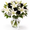 Bouquet of white lilies and black roses in a glass vase