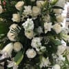 Large white floral standing spray with roses and lilies on an easel