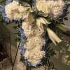 Standing floral cross with white and blue flowers on an easel