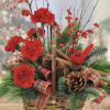 Red carnations in a basket with pinecones, plaid ribbon, and a red cardinal ornament