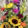 Tall mixed flower arrangement with sunflowers, roses, and purple blooms in a basket