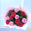 Hand-tied bouquet of red and pink roses wrapped in soft pink paper