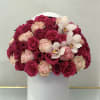 Bouquet of pink and blush roses with white orchids in a white hat box