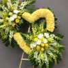 Two yellow and white floral wreaths on easels against a gray wall
