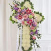 Standing floral cross with pink roses, lilies, and white blooms