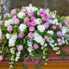 Pink and white floral casket spray with roses and carnations