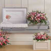 Pink floral funeral casket spray with matching arrangements and heart wreath