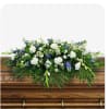 White and blue floral spray on a wooden casket