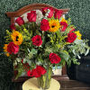Bouquet of red roses and sunflowers in a clear glass vase