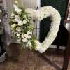 White floral heart-shaped standing spray on an easel