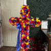 Large floral cross arrangement with red, yellow, purple, and pink flowers