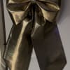 Large metallic gold bow on a white surface