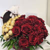 Red roses with gold-wrapped chocolates and a small teddy bear in a box