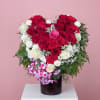 Heart-shaped bouquet of red and white roses in a dark vase