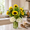Sunflower and white hydrangea arrangement in a clear glass vase