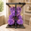 Purple rose teddy bear in a clear gift box with a ribbon