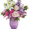 Pink and white floral arrangement in a purple vase