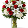 Red roses and white lilies in a clear glass vase