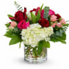Bouquet of red and pink roses with white hydrangea in a glass vase