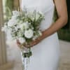 Bride holding a white bouquet with trailing bead strands