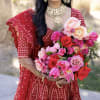 Woman in red dress holding a bouquet of pink and red flowers