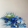 Blue floral arrangement with orchids and roses in a rectangular vase