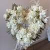 Heart-shaped white rose wreath on a stand