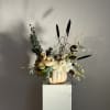 Pumpkin arrangement with white flowers and dark ornamental grasses