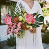 Bride holding a tropical bouquet with pink anthuriums and orchids