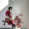Pink and black floral arrangement in a ribbed vase