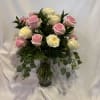 Pink and white roses arranged in a glass vase