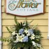 Large floral arrangement with white lilies and blue hydrangeas in a vase