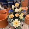 Light roses, dahlias and texture galore make this arrangement stand tall compared